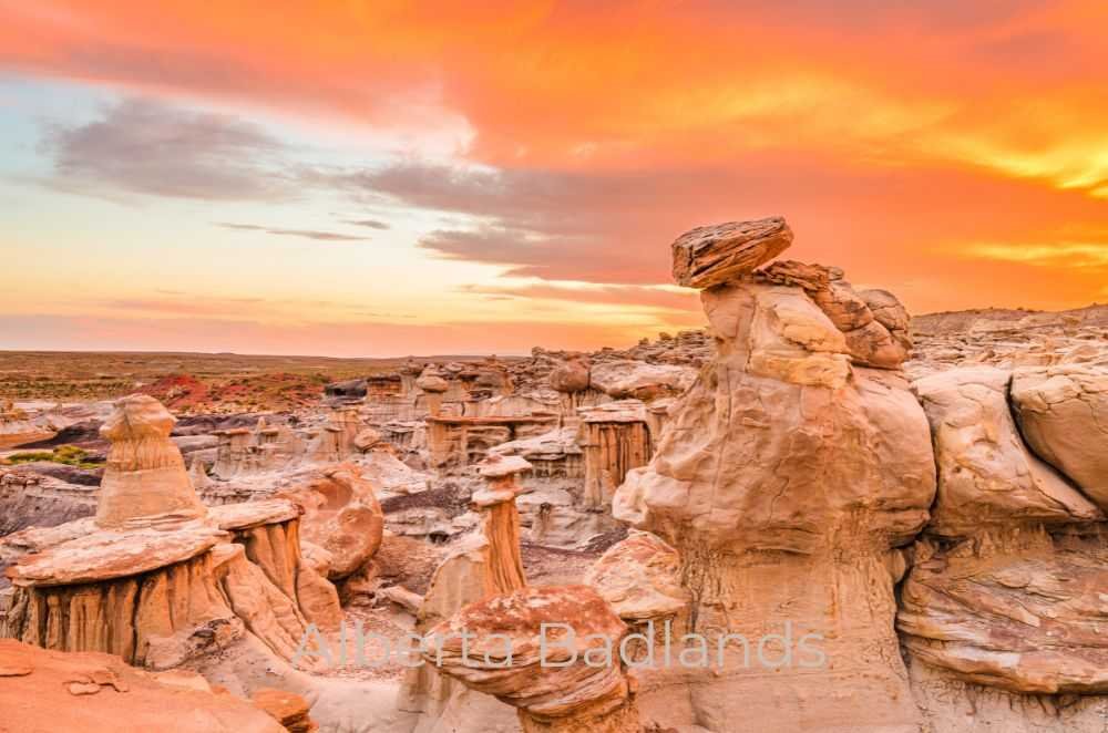 Image of rock formations in the Alberta Badlands during a vibrant sunset with colorful clouds in the sky, capturing the essence of Dinosaur Provincial Park.