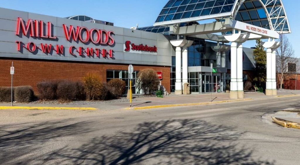 Entrance of Mill Woods Town Centre with signage for Scotiabank. The building has a glass-covered walkway and a clear blue sky above, offering a pleasant shopping experience similar to other premier shopping malls in Edmonton like South Edmonton Common.