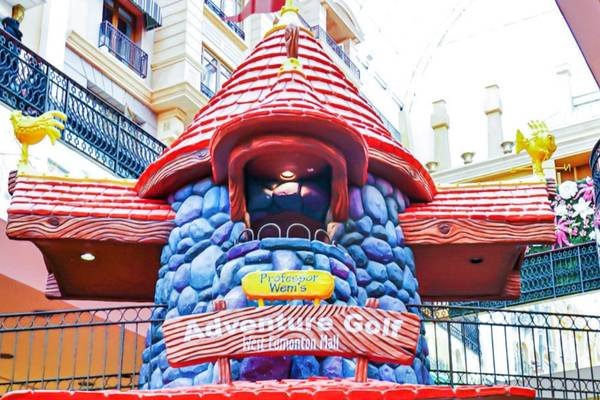 An entrance to Professor Wem's Adventure Golf in West Edmonton Mall, featuring a colorful, whimsical building designed with stone and wood textures. Among the many West Edmonton Mall attractions, this one stands out for its unique charm and playful architecture.