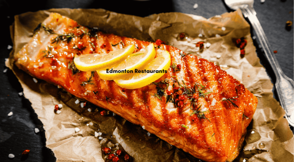 Grilled salmon fillet topped with lemon slices and herbs, a dish reminiscent of the flavors found in some of the best restaurants in Edmonton, elegantly presented on parchment paper.