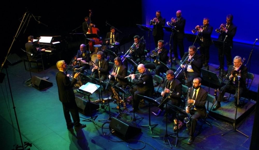 A jazz orchestra dazzles with live music in Edmonton, as a conductor leads musicians playing trumpets at Yardbird Suite