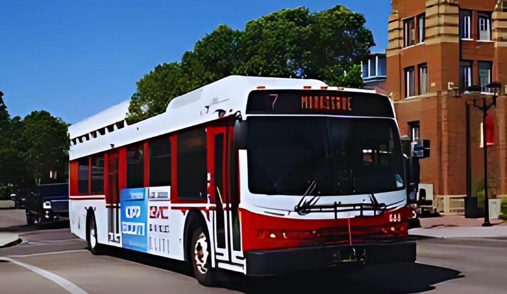 A Red Deer Transit bus labeled with route 7 navigates along the street, framed by a backdrop of trees and buildings.