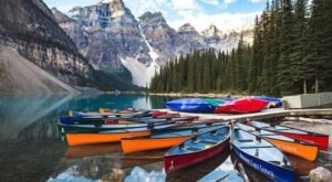 Multiple colorful canoes are lined up at Moraine Lake—one of the best things to do in Banff for nature lovers.