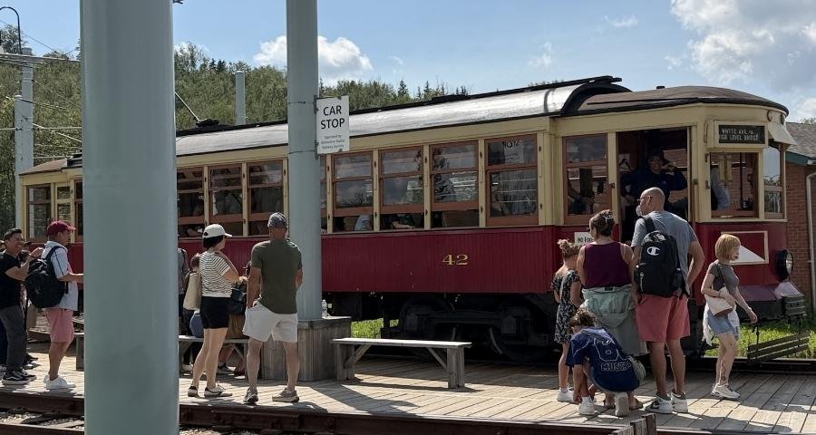 People wait and board One of the street cars at Fort Edmonton Park.